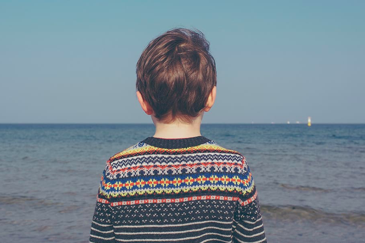 child staring at the ocean